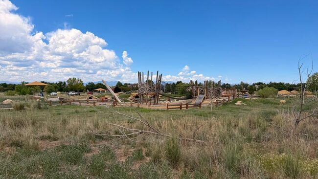Nature play area at McKay Lake Park with logs and climbing features