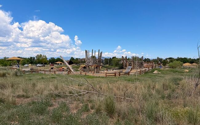 Nature play area at McKay Lake Park with logs and climbing features