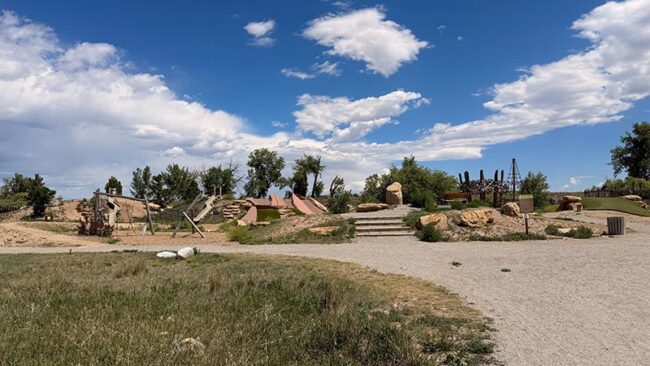 Nature play area at McKay Lake Park with logs and climbing features