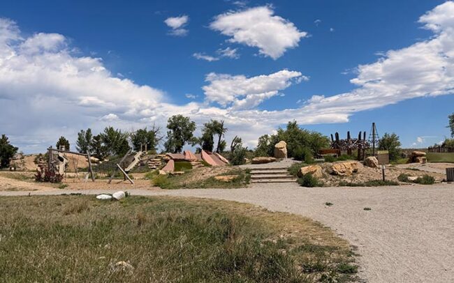 Nature play area at McKay Lake Park with logs and climbing features