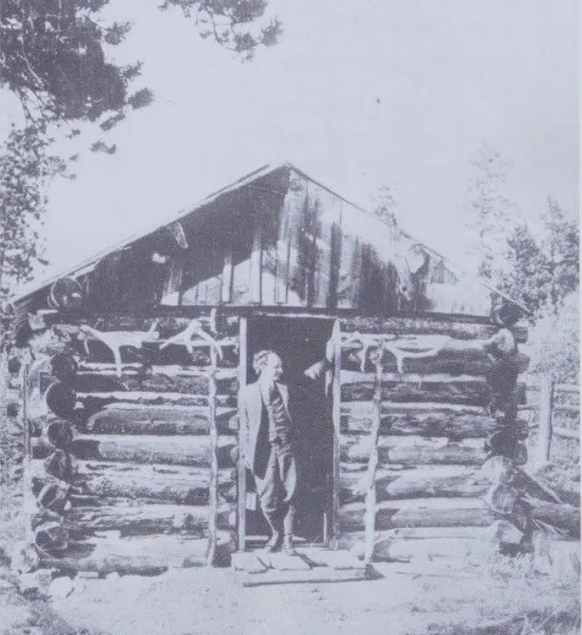 Enos Mills at a cabin doorway on Longs Peak, photographed before 1922.
