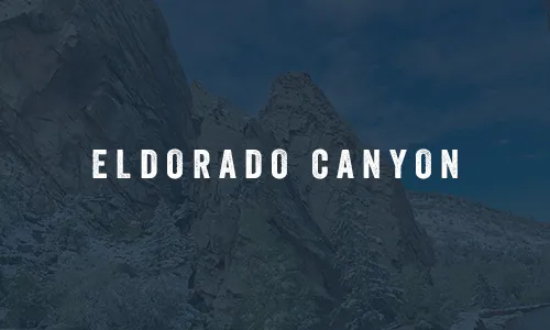 Snowy Eldorado Canyon rock formations beneath a bright blue sky