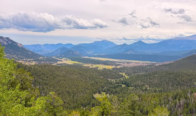 Wide view of Rocky Mountain National Park valleys and distant peaks from Rainbow Curve Overlook