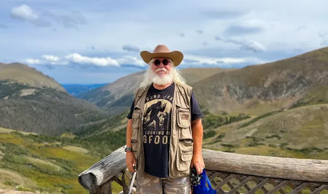 Visitor standing at an Alpine Visitor Center overlook above an alpine valley in Rocky Mountain National Park