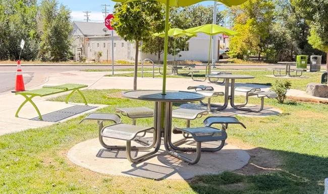 Shaded picnic tables with green umbrellas at Westminster Station Park