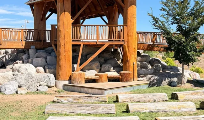 Timber play shelter and log seating in the nature playground at Westminster Station Park