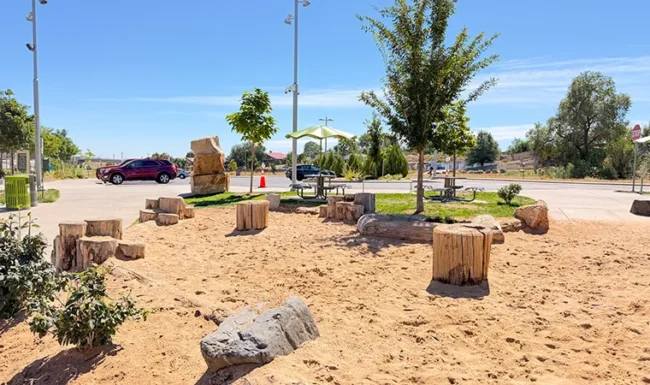Sand play area with log stepping features at Westminster Station Park Nature Playground