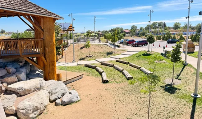 Natural play area with logs, boulders and wooden structures at Westminster Station Park