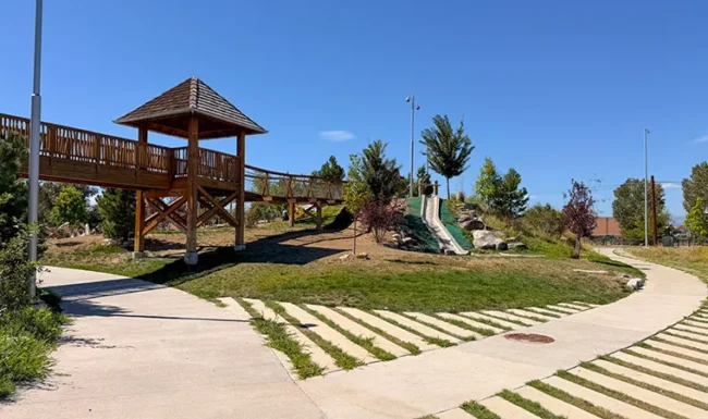 Wooden bridge, hillside slide and walking path at Westminster Station Park Nature Playground