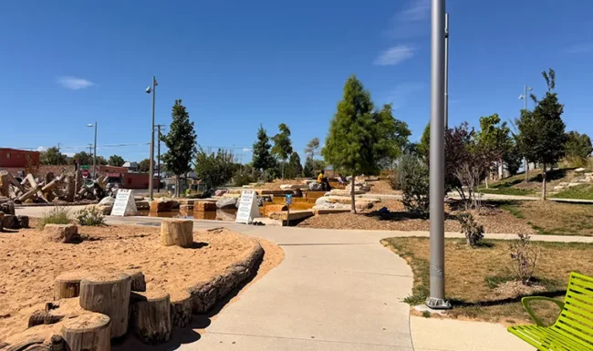 Paved path beside sand and water play areas at Westminster Station Park Nature Playground