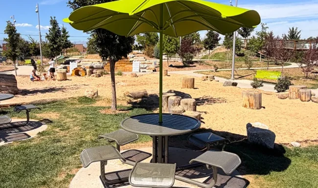 Umbrella-shaded picnic table overlooking the nature playground at Westminster Station Park