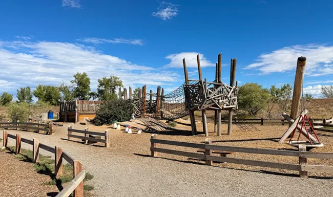 Wooden climbing structure with rope bridge at McKay Lake Park’s nature playground in Broomfield