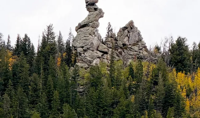 Granite rock formation above pine forest and golden aspens in Golden Gate Canyon State Park, Colorado