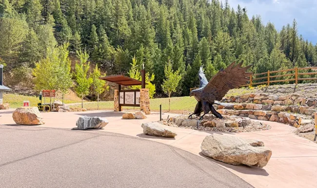 Bronze black hawk sculpture and signage at Hidden Treasure trailhead