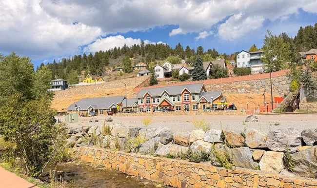 Downtown Black Hawk buildings below forested mountain slopes
