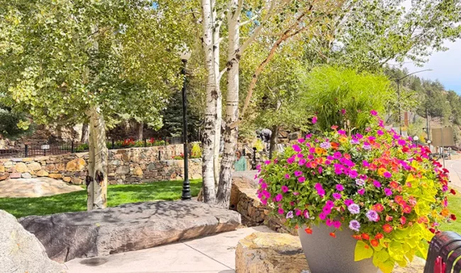 Flower-filled planter, trees and stone waterfall: Mountain Life Park in Black Hawk, Colorado