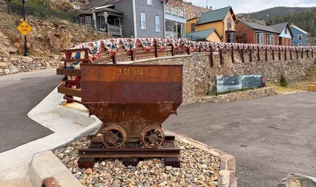 Historic mining ore cart displayed beside a Black Hawk street