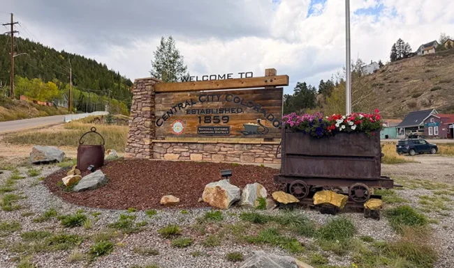 Welcome to Central City, Colorado sign with historic mining cart planter