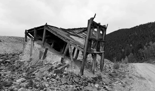 Weathered wooden mining ore bin beside a dirt road near Central City, Colorado