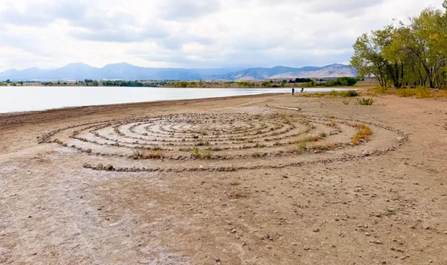 Exposed sandy shoreline with man-made rock design at Boulder Reservoir