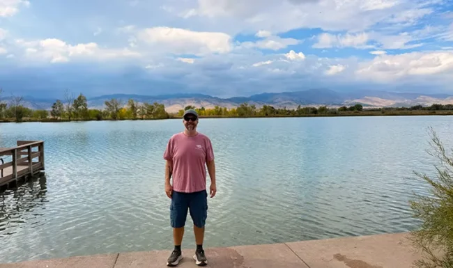 Hiker standing beside Coot Lake with Front Range views