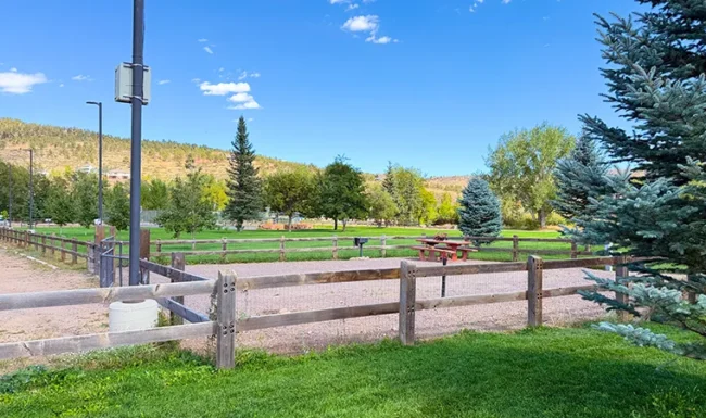 Fenced walking path and open park space at Bohn Park in Lyons, Colorado