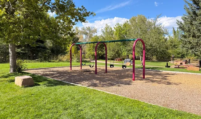 Swingset beside open green space at Bohn Park in Lyons, Colorado