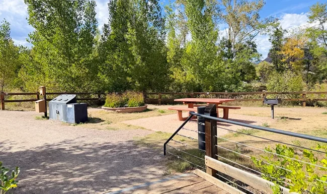 Riverside picnic area with grill and picnic table at Bohn Park in Lyons, Colorado