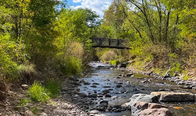 Rocky St. Vrain Creek with pedestrian bridge at Bohn Park in Lyons, Colorado