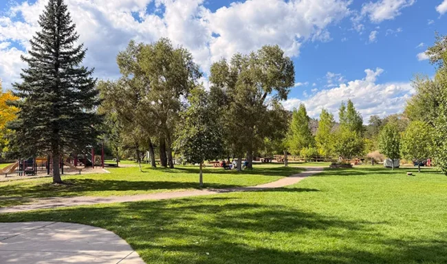 Paved walking path through open green space at Bohn Park in Lyons, Colorado