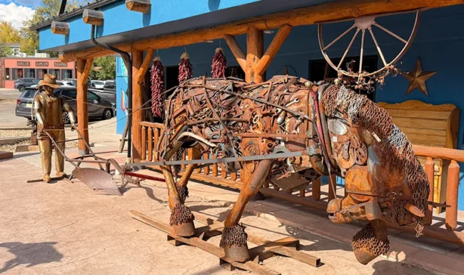 Metal horse, plow and farmer sculpture outside a downtown Lyons business