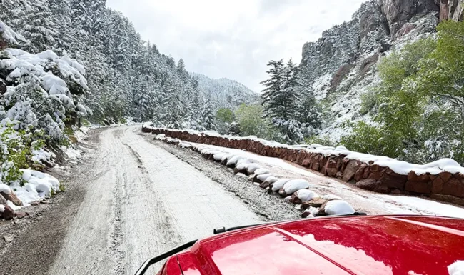 Fred's red pickup driving through snowy Eldorado Canyon, Colorado