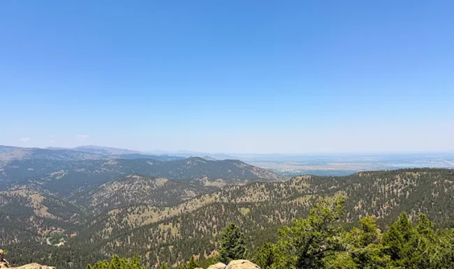 Sweeping view of forested mountain ridges and distant plains from Lost Gulch Overlook