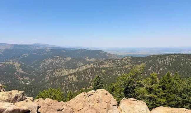 Large foreground boulders overlooking pine-covered hills at Lost Gulch Overlook