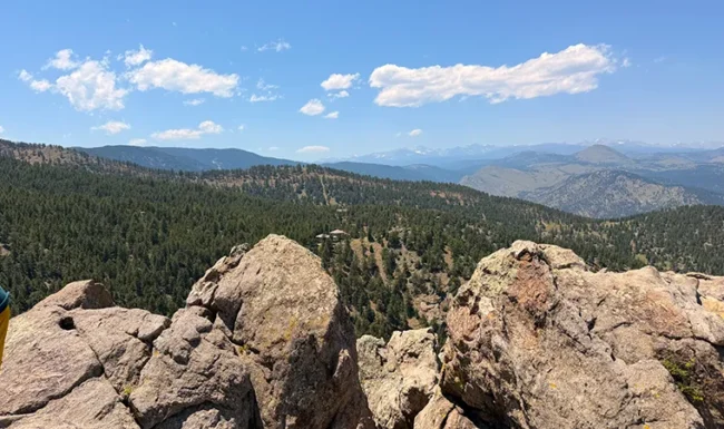 Rugged boulders at Lost Gulch Overlook above a forested valley with mountains beyond