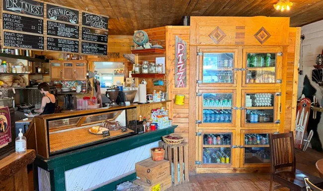 Gold Hill General Store counter with chalkboard menus, a pastry display and a wooden beverage cooler.