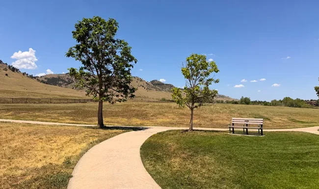 Walking path, park bench and foothill views at Foothills Community Park in Boulder Colorado