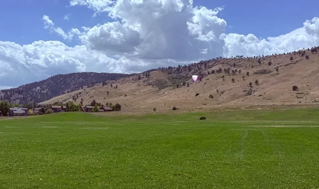 Paraglider over a grassy field with foothill views at Foothills Community Park in Boulder Colorado