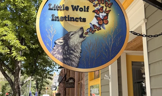 Little Wolf Instincts storefront sign along Main Street in downtown Lyons