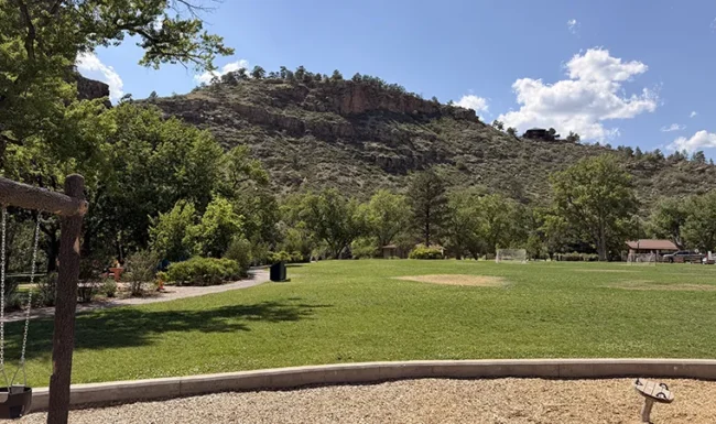 Open lawn and playground area surrounded by foothills at LaVern M. Johnson Park in Lyons