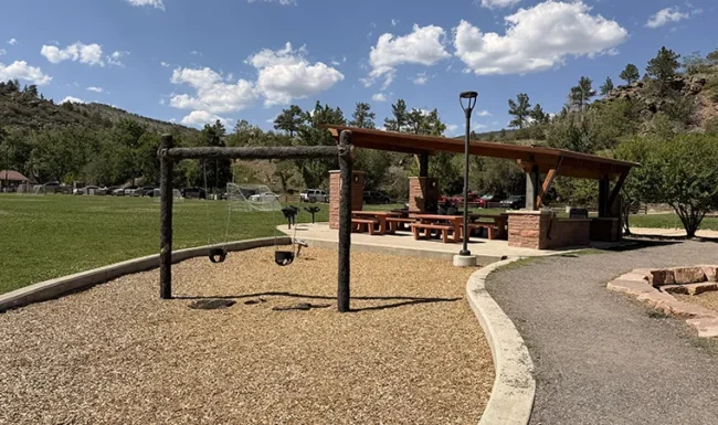 Playground swings, picnic shelter and grassy field at LaVern M. Johnson Park in Lyons