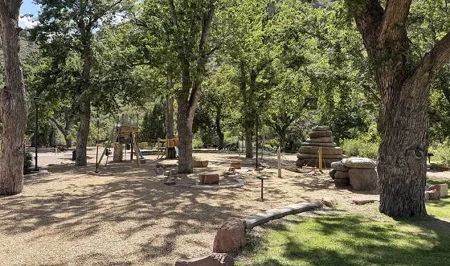 Shaded playground and nature play area at LaVern M. Johnson Park in Lyons