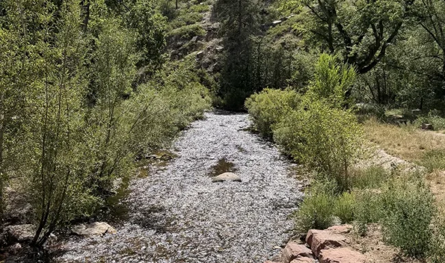 North St. Vrain Creek flowing below rugged cliffs at LaVern M. Johnson Park in Lyons