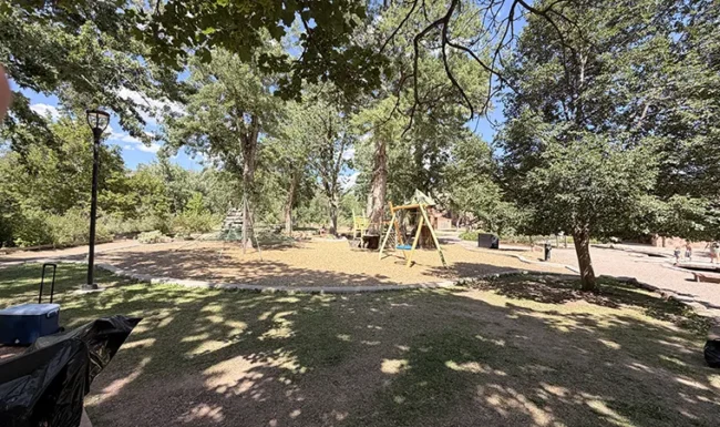 Shaded playground with swings and climbing equipment at LaVern M. Johnson Park in Lyons