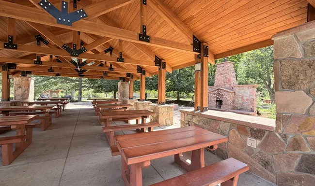 Covered picnic pavilion with picnic tables and stone fireplace at LaVern M. Johnson Park