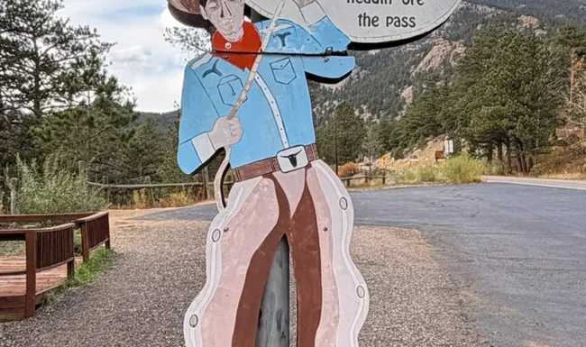 Pioneer-themed roadside sign near the Fall River Gateway Visitor Center